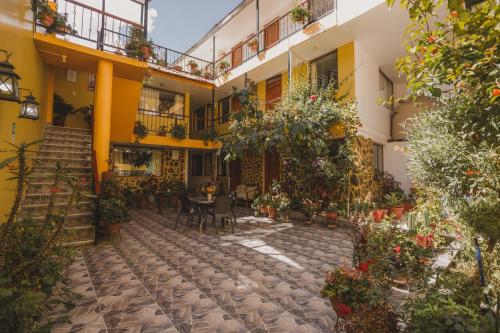 a courtyard of a building with a table and chairs at Intitambo Hotel in Ollantaytambo