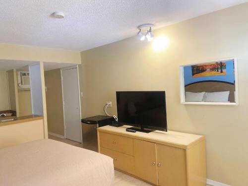a bedroom with a bed and a flat screen tv at Slumber Lodge in Hope