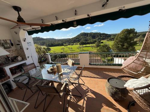 a patio with a glass table and chairs on a balcony at FLAT Surrounded by Nature WIFI & Pool & beach Nearby in Son Parc