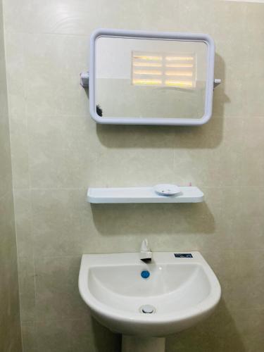 a bathroom with a sink and a mirror on the wall at Yu T Home Stay Anuradhapura in Anuradhapura