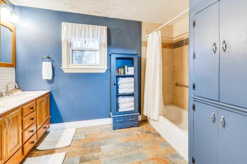 a bathroom with blue walls and a sink and a tub at Less Than 1 Mi to Main St Berryville Spacious Family Home in Berryville