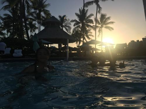 Una mujer en una piscina de un resort en 4 Bdrm House for 8 at Kamilo, Mauna Lani -- Ride Bikes or Walk To Beach, en Waikoloa