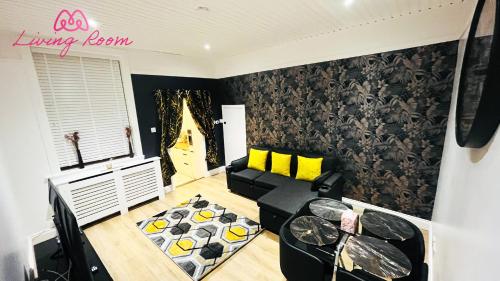 a living room with a black couch and yellow pillows at Ground Floor Entire Apartment Self Checkin in Crossgates