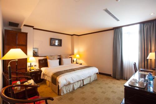 a hotel room with a bed and a window at Rich Garden Hotel in Taipei