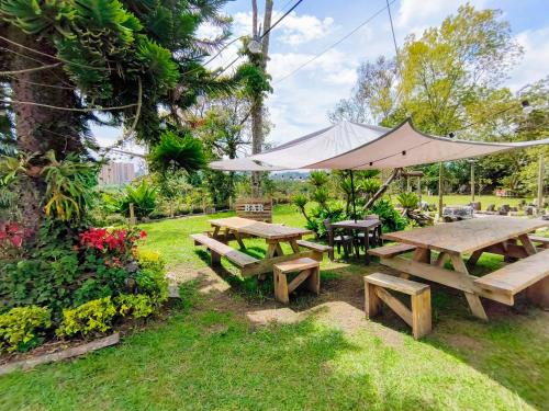 a picnic table and an umbrella in a yard at Hermosa Finca El Castillo - Excelente Ubicación Rionegro Marinilla in Rionegro