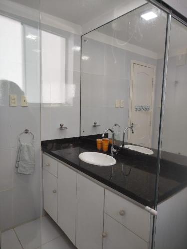 a bathroom with a sink and a mirror at Habana Flats Praia in Natal