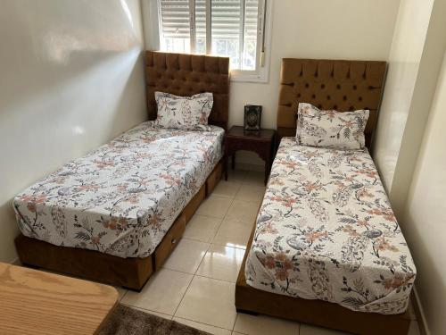 a bedroom with two beds and a window at Appartement de luxe in Casablanca