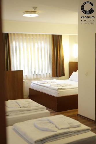 a hotel room with two beds and a window at Hotel Centrum Prizren in Prizren