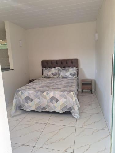 a bedroom with a bed with a quilt on it at Chalé Roda Dágua B in Alto Caparao