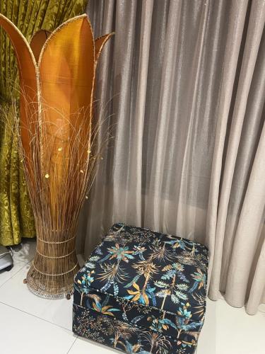 a ottoman and a vase next to a curtain at Ambience on N2 Boutique Hotel in Kokstad