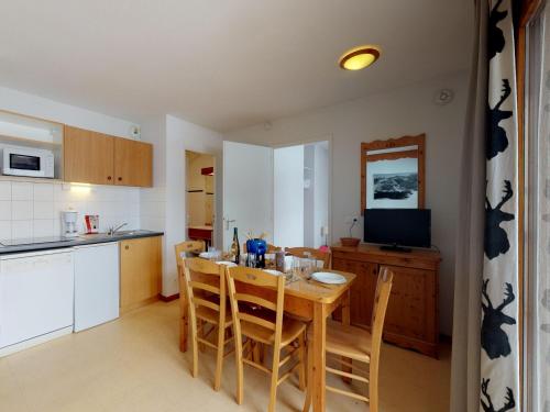 Il comprend une cuisine avec une table en bois, des chaises et une télévision. dans l'établissement Apartment in Termignon near Gondola, à Val Cenis