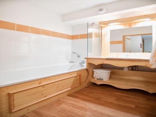 une salle de bain avec une baignoire, un lavabo et un miroir dans l'établissement Apartment in Orelle with Pool & Sauna, à Orelle