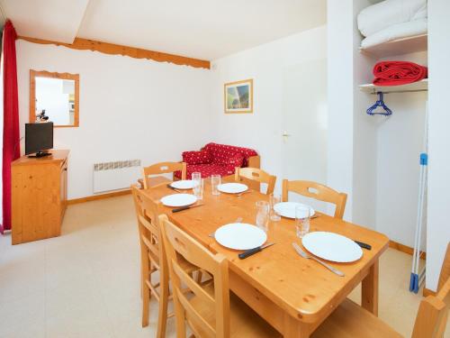 une salle à manger avec une table et des chaises en bois dans l'établissement Apartment in Termignon near Gondola & Views, à Val Cenis