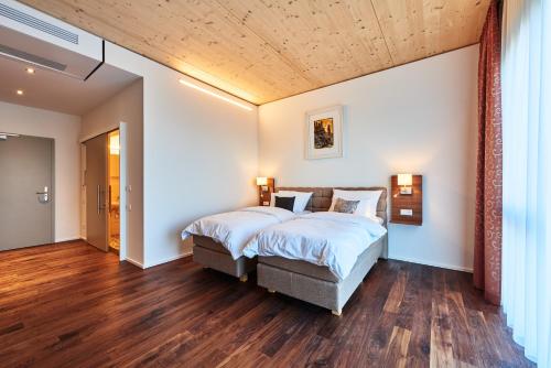 ein Schlafzimmer mit einem großen Bett und einer Holzdecke in der Unterkunft Hotel 2050 in Rutesheim
