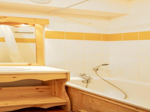 une salle de bain avec un lavabo et une baignoire dans l'établissement Apartment in Orelle with Pool & Sauna Access, à Orelle