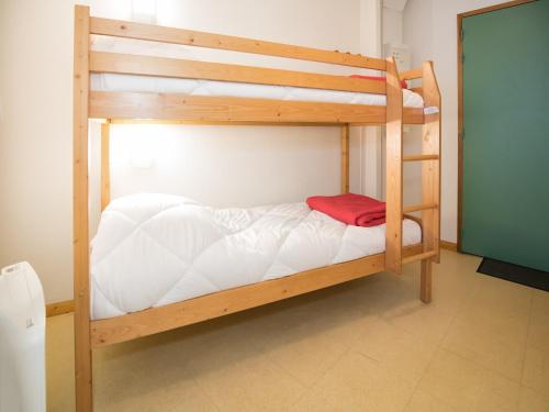 - un lit superposé en bois avec des draps blancs et une couverture rouge dans l'établissement Studio in Termignon near Ski Lift, à Val Cenis