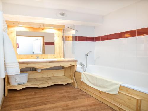 une salle de bain avec un lavabo, une baignoire et un miroir dans l'établissement Apartment in 3 Vallées with Pool & Sauna, à Orelle