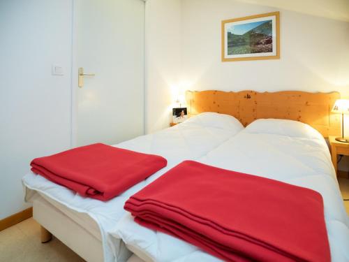 - deux serviettes rouges assises au-dessus d'un lit dans l'établissement Apartment Termignon near Ski Lift, à Val Cenis