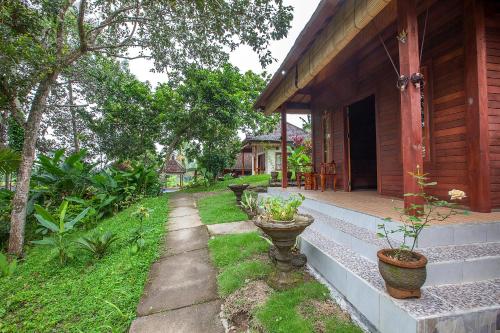 a porch of a house with potted plants on it at Pondok Hari Baik in Balian