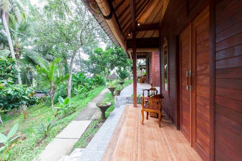 a porch of a house with a wooden door at Pondok Hari Baik in Balian