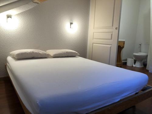 un lit blanc avec deux oreillers dessus dans l'établissement Chalet in Valfréjus near Ski Lifts, à Modane