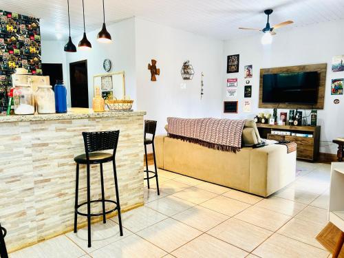 a living room with a couch and a bar at CASA COM SPA DE HIDRO, AQUECEDOR E CROMOTERAPIA A 1,0 kM DO CENTRO in Chapada dos Guimarães