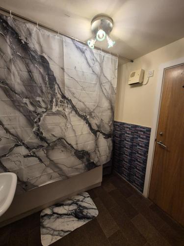 a bathroom with a marble shower curtain and a sink at Modern 2 Bedroom Apartment Unbeatable City Centre Location! in Bradford