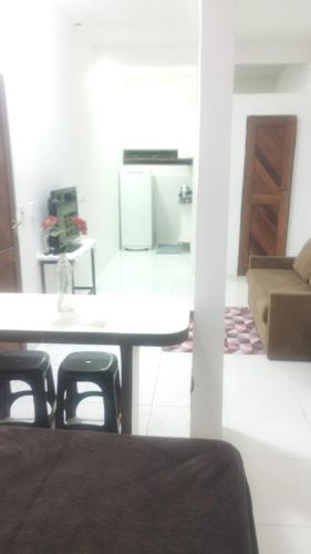 a room with a table and chairs and a kitchen at Studio 4 pessoas in Salvador