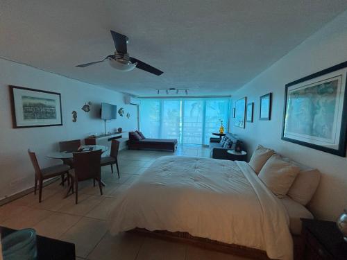 a bedroom with a large bed and a dining room at Ocean view Studio Marina Lanais in Fajardo