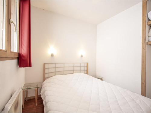 une chambre avec un lit blanc et un rideau rouge dans l'établissement Apartment Valfréjus near Ski Lifts, à Modane