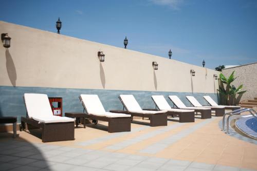 a row of white lounge chairs on a patio at Crown Hotel Juba in Juba