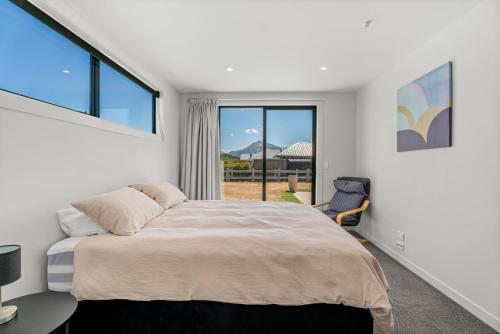 a bedroom with a large bed and a window at The Alpine Patch - Wanaka Holiday Home in Wanaka