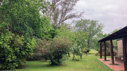 a garden with trees and a pavilion and a bench at Gran Quinta en Mercedes con piscina in Mercedes