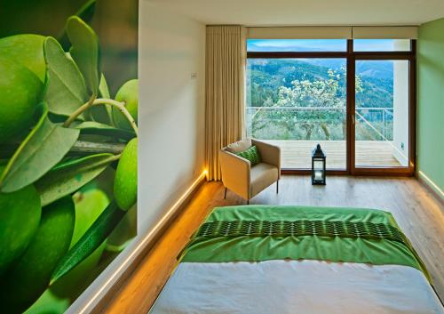a room with a green couch and a large window at 12 Meses Naturalmente in Cerdeira