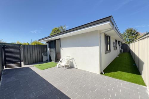 a chair sitting on a patio next to a house at B2 Airport Adjacent Home - New Amenities & Fast Wi-Fi in Perth