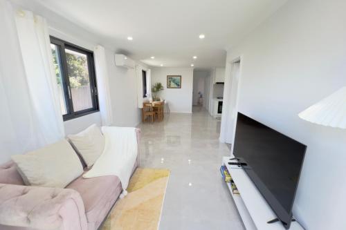 a living room with a couch and a flat screen tv at B2 Airport Adjacent Home - New Amenities & Fast Wi-Fi in Perth