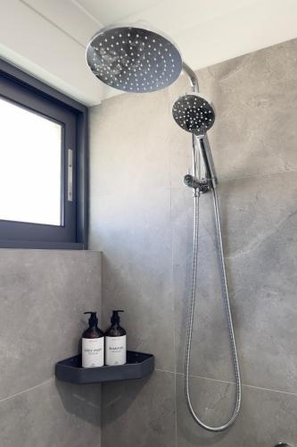 a shower in a bathroom with two bottles at B2 Airport Adjacent Home - New Amenities & Fast Wi-Fi in Perth