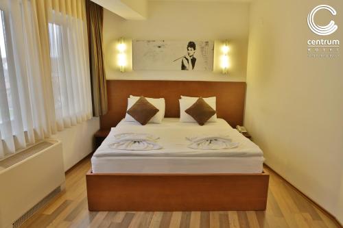 a bedroom with a bed with white sheets and pillows at Hotel Centrum Prizren in Prizren