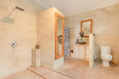a bathroom with a toilet and a mirror at Villa Toto Seminyak in Seminyak