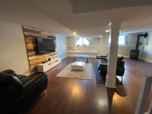 a living room with black furniture and a flat screen tv at 1Bed Cozy Retreat & Spacious Lounge in Yellowknife