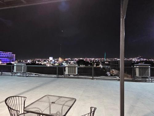 two chairs sitting on top of a roof at night at Hotel The Roof in León