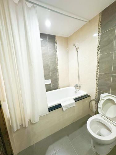 a bathroom with a bath tub and a toilet at Green Hill Hotel Phayao in Phayao