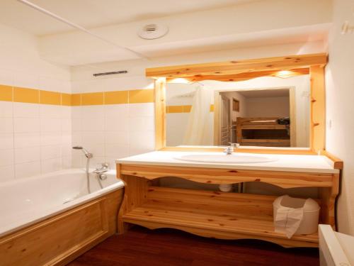 une salle de bain avec un lavabo, une baignoire et un miroir dans l'établissement Apartment in Valfréjus near Gondola, à Modane