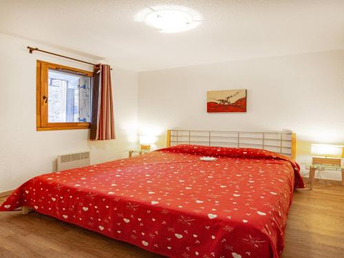- une chambre avec un lit doté d'un couvre-lit rouge dans l'établissement Apartment in 3 Vallées near Ski Lift, à Orelle