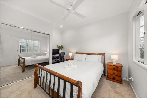 a bedroom with a large bed and a desk at Charming 1-Bed Cottage with Garden Retreat in Bald Hills