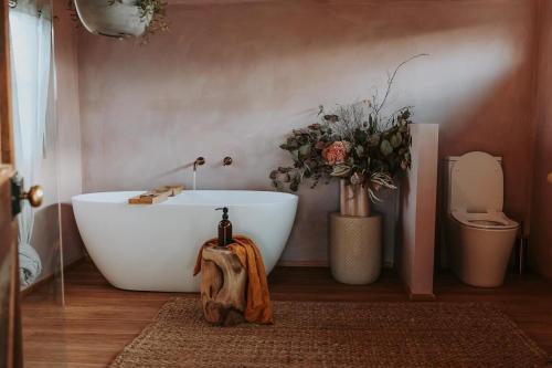 a bathroom with a white tub and a toilet at Simplistic Luxury Cottage, Ross in Ross