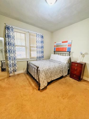 a bedroom with a bed and a dresser and a window at Rose's comfortable place in Munhall