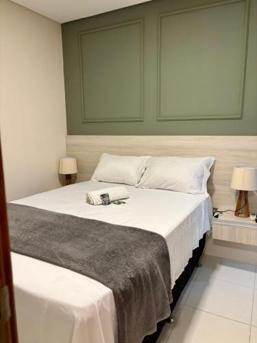 a bedroom with a large white bed with two lamps at Flat Rosarinho II - Confortável e Super Completo in Recife