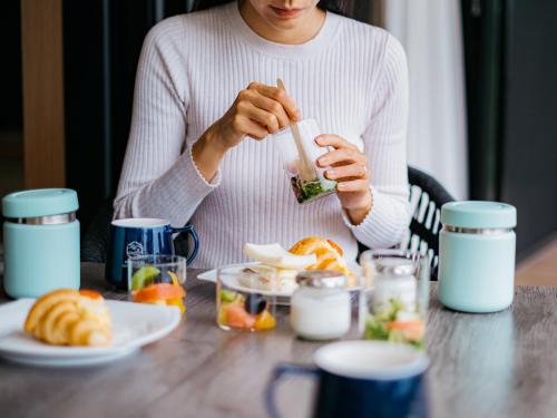 a woman sitting at a table eating food at 瀬戸内ゴルフリゾートヴィラ in Takekara