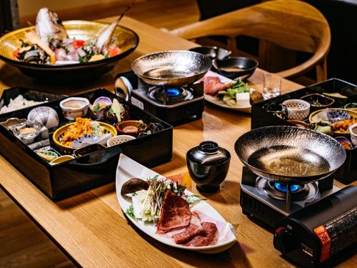 a wooden table with plates of food on it at 瀬戸内ゴルフリゾートヴィラ in Takekara